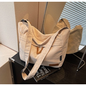 Vue détaillée du sac cabas en toile crème avec tissu texturé et bandoulière