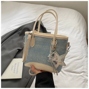 Détail du sac seau en denim avec pois en cristal blanc et breloque argentée