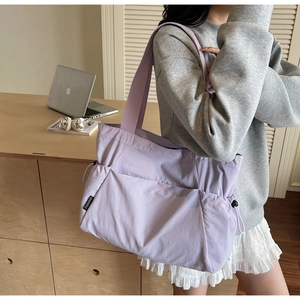 Detail of lavender nylon tote bag with side drawstring pockets for commute use