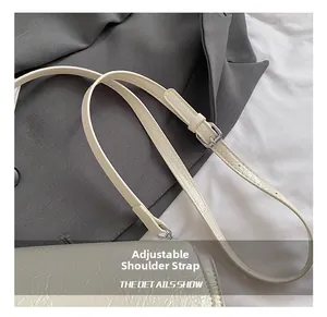 Détail de la bandoulière réglable en cuir crème avec boucle argentée et texture plissée