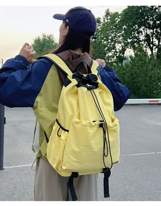 Rear view of model wearing the lightweight yellow water-resistant drawstring backpack