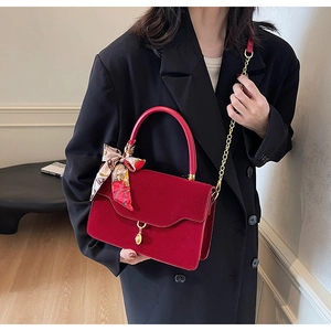 Detail of red velvet bridal handbag with silk scarf handle and gold chain strap