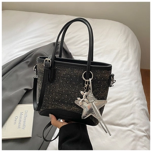Détail du sac seau en denim à pois avec breloques d'étoile et chien ballon