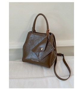 Detail of dark brown vintage oil-wax texture tote bag with matching envelope charm pouch