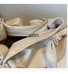 Detail view of smooth metal zipper closure and fabric lining on beige tote bag