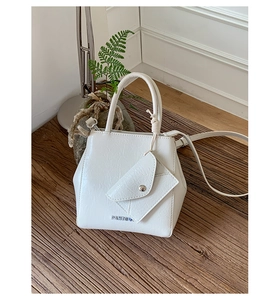Close-up of white cracked texture leather handbag with mini pouch and metal logo