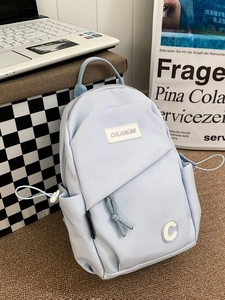 Light blue canvas crossbody chest bag with front pocket and side drawstring details