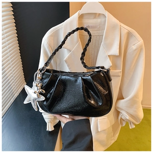 Détail du sac nuage plissé noir brillant avec poignée tressée et breloques en étoile
