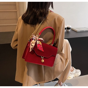 Elegant red wedding handbag featuring silk scarf handle and gold chain strap detail