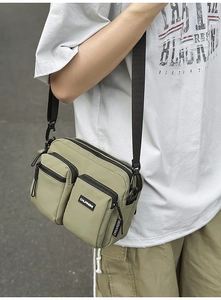 Detail of olive green nylon crossbody bag showing multiple pockets and water-resistant fabric