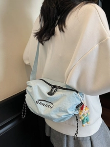 Light blue nylon dumpling crossbody bag with brand logo and cute charm for women