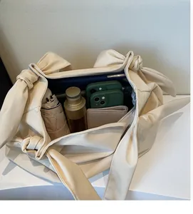 Spacious interior of a cream tote bag showing capacity for tablets and daily essentials