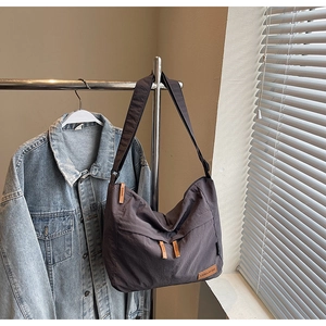 Gros plan d'un grand sac cabas en toile gris foncé avec détails en cuir et nylon texturé