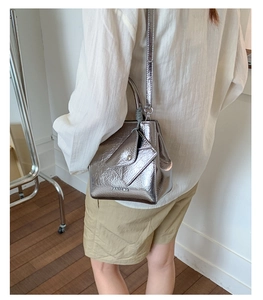 Detail of silver metallic crossbody bag with crackle finish and mini triangle pouch accessory