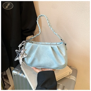 Détail du sac en cuir verni bleu clair plissé avec breloque étoile et poignée tissée main
