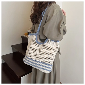 Close-up of hollow knit tote bag with blue stripes and mesh texture for summer beach use