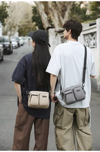 Outdoor street view of a multi-pocket canvas crossbody bag with adjustable strap
