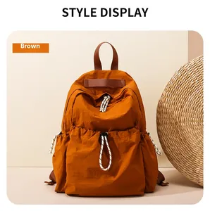 Detail view of brown water-resistant nylon backpack with woven drawstring and textured fabric