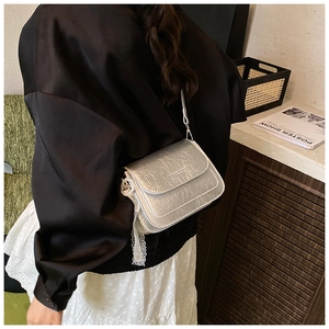 Petit sac bandoulière argenté plissé avec dentelle porté par un mannequin de profil