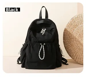 Detailed close-up of a black lightweight nylon backpack with stylish woven drawstrings