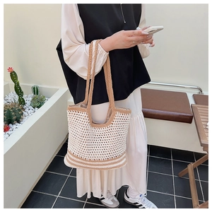 Dettaglio della borsa tote all'uncinetto con trama bicolore beige e manico a righe