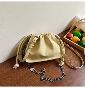 Detail der cremeweißen Cloud-Bucket-Bag mit Silberkette und Markenprägung am Taschenboden