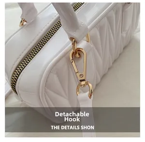 Detail of white quilted crossbody bag with golden metal zipper and detachable shoulder strap hook