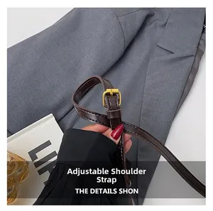 Détail de la bandoulière réglable en cuir marron foncé avec boucle en métal doré