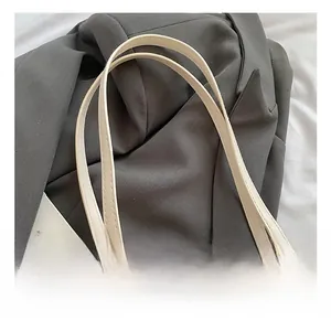 Detailaufnahme der Tragetasche mit Litchi-Leder, Goldlogo und Katzenprägung