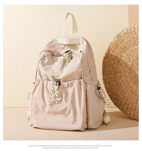 Detail of light beige water-repellent nylon backpack with functional drawstring pocket