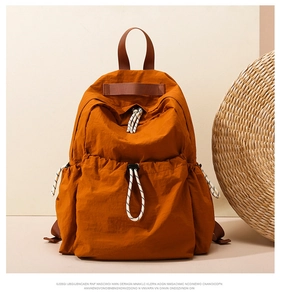 Close-up of caramel nylon backpack with drawstring pockets and woven texture handle