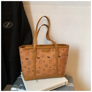 Nahaufnahme braune Leder-Einkaufstasche mit Bärenprint auf einem silbernen Koffer