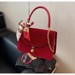 Red velvet bridal handbag with gold chain strap and elegant silk scarf detail