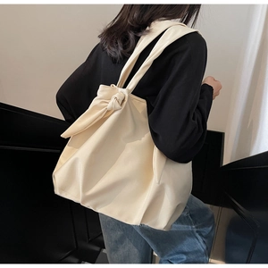 Off-white tote bag detail showing the elegant bow knot design on the shoulder strap