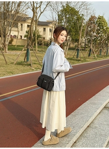 Detail of a black nylon crossbody bag with multiple zip pockets and adjustable strap