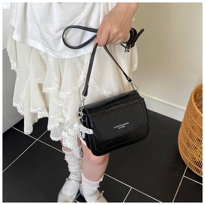 Détail du sac noir vintage texturé avec breloque en perles et finitions argentées