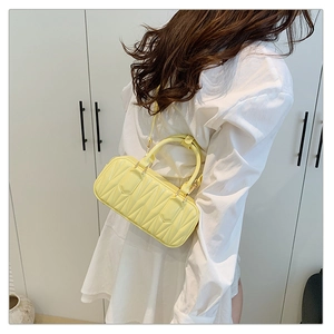Model showcasing a bright yellow crossbody bag with unique 3D folded diamond texture