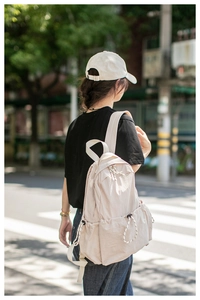 Detail of pink lightweight travel backpack showing drawstring pockets and padded straps