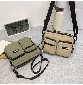 Detail of lightweight nylon crossbody bags in olive green and khaki with multi-pockets