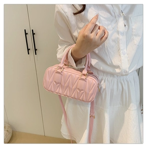Detailed close-up of pink quilted jelly handbag with glossy finish and gold metal hardware