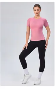 Detailed view of pink compression workout tee with reinforced seams and crew neck style