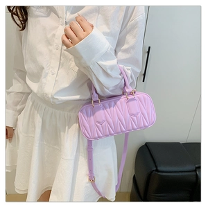 Detailed view of lavender quilted crossbody bag with top handles and golden hardware