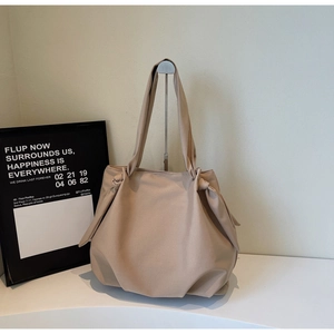 Detail view of khaki minimalist tote bag featuring elegant pleated texture and knotted handle