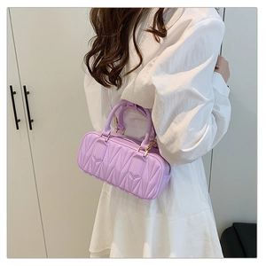 Lavender purple quilted crossbody bag with top handles and gold hardware shown on model