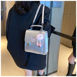 Sac à main argenté avec broderie papillon rose et pendentif en peluche détaillé