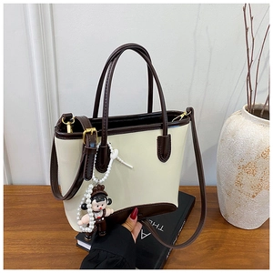 Détail du sac cabas contrasté avec pendentif dessin animé et breloque en perle