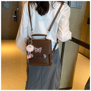 Sac à dos vintage en cuir marron avec motif papillon blanc et breloque peluche rose