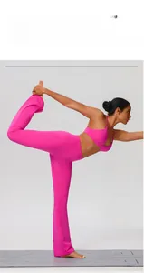 Detail of high-stretch fuchsia yoga set with flared pants shown in a yoga stretch pose