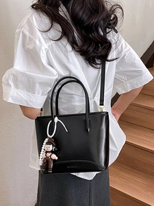 Sac à main chic en cuir noir brillant avec breloques et bandoulière amovible