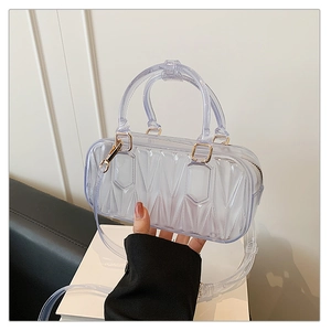 Detail of transparent PVC crossbody bag with quilted texture and gold-tone hardware